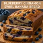 Close-up of Blueberry Cinnamon Swirl Banana Bread slice with blueberries and cinnamon.