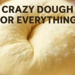 Crazy dough for everything in a bowl on a wooden countertop with flour and rolling pin