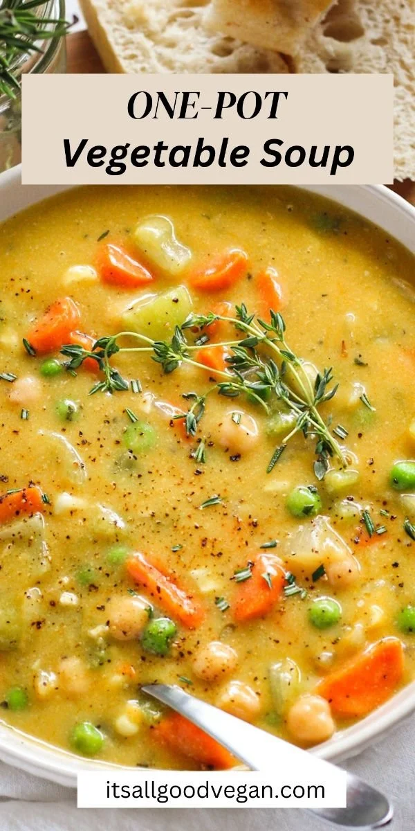 Bowl of creamy vegetable soup with colorful vegetables and herbs on top