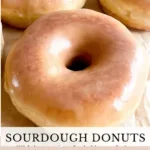 Freshly glazed sourdough donuts on a cooling rack