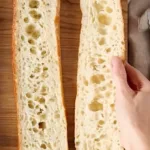 Freshly baked sourdough baguette with a golden crust and airy interior.