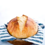 Loaf of 4-ingredient gluten free sourdough bread on a wooden cutting board