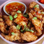 Air fryer crispy chilli chicken served with fresh vegetables and garnishes