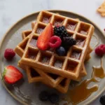 Delicious crispy buckwheat waffles served with fresh berries and syrup