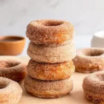 Gluten-free baked donuts fresh out of the oven on a cooling rack.