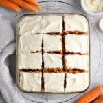Slice of gluten-free carrot cake topped with cream cheese frosting and walnuts
