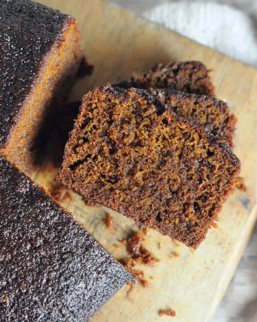 Delicious gluten-free ginger cake topped with frosting on a wooden table.