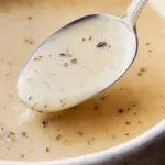 Bowl of delicious gluten-free gravy served over mashed potatoes.