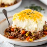 Delicious gluten-free Shepherd's Pie served in a bowl with fresh herbs on top.