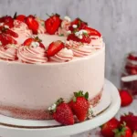 Gluten-free strawberry cake topped with fresh strawberries and whipped cream