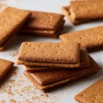 Batch of homemade gluten-free graham crackers on a wooden board.
