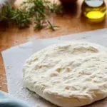Homemade pizza dough ready for baking and topping with ingredients.
