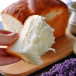Freshly baked Tangzhong White Bread loaf on a wooden cutting board